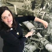 female in front of a black and white photo of water pipes